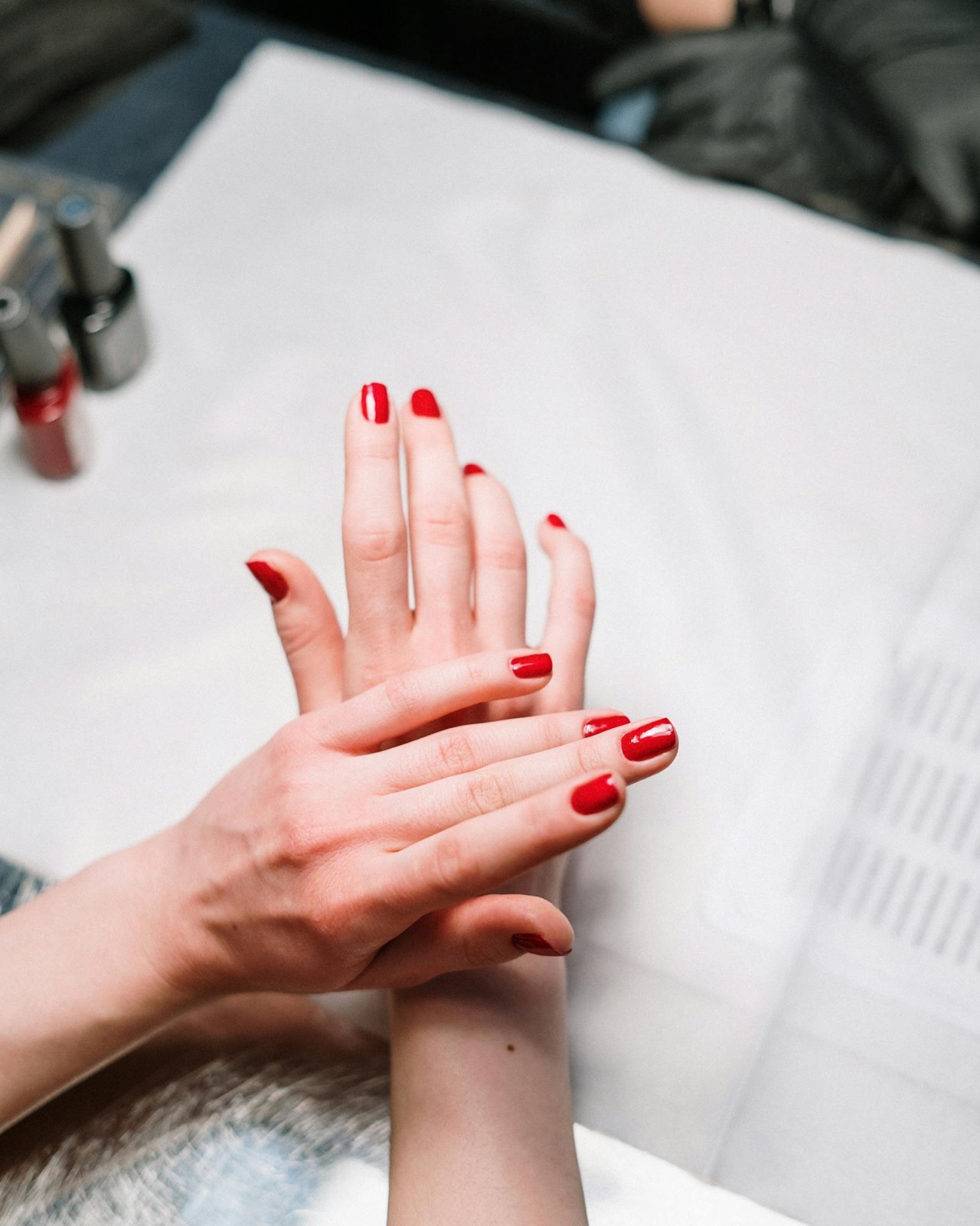 Manicured hands with red gel polish, close-up